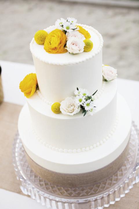 Piece of Cake: The Cake Stand made the classic carrot and vanilla cake, which the bride dressed up with fresh flowers and a burlap-wrapped stand.