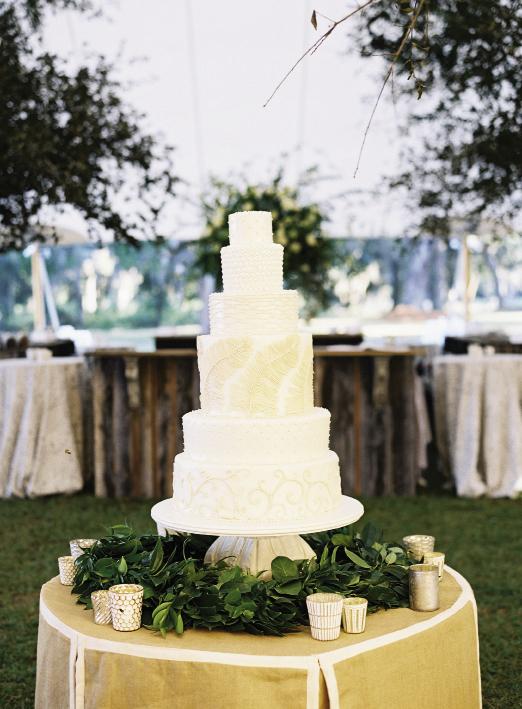 Catering to  reception-goers’ varied tastes  (and the bride’s major sweet  tooth), Wedding Cakes by Jim Smeal baked a six-tier beaut featuring chocolate, almond, and coconut flavors. Cake by Wedding Cakes by Jim Smeal. Florals by Blossoms Events. Photograph by Tec Petaja.