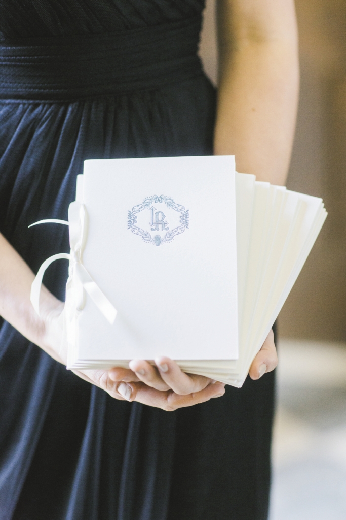 His-and-her monograms topped letterpressed program booklets that were finished with ribbon. Stationery by Ceci New York. Image by Elisabeth Millay Photography.