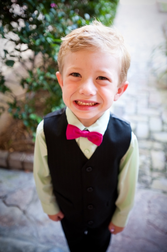 WELL SUITED: Matching the floral color palette, the ring bearer sported a fuchsia bowtie and cheery smile.