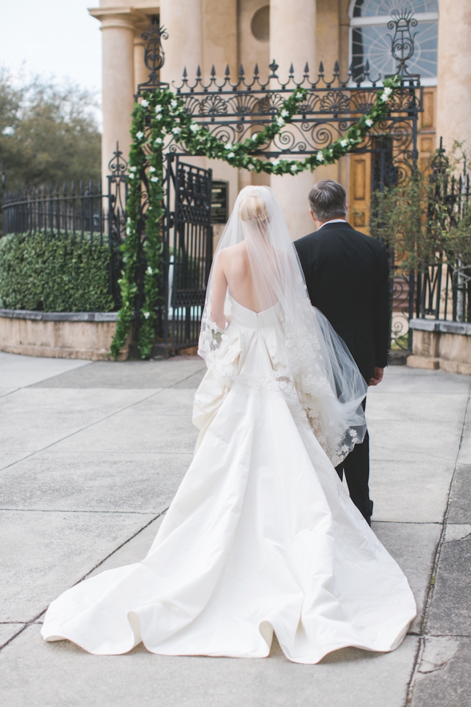 Bride&#039;s gown and veil by Oscar de la Renta. Menswear by Grady Ervin &amp; Co. Florals by Gathering Floral + Event Design. Image by Elisabeth Millay Photography at St. Philips Church.