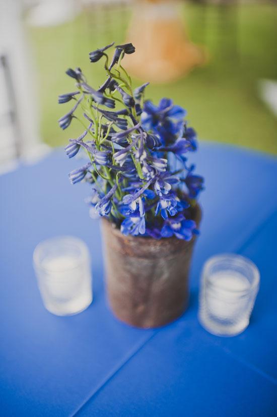 NICE TOUCH: Reception tables were tastefully topped with centerpieces like this one: an earthenware pot of blue delphinium flanked by votive candles.