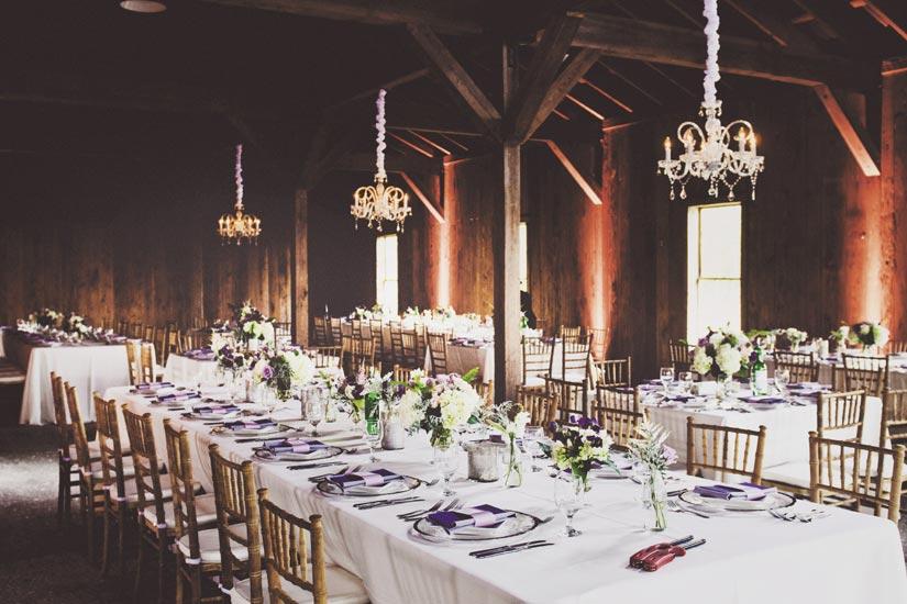 AMETHYST LUXURY: Emerald green wine bottles placed next to centerpieces of maidenhair fern, roses, raspberries, sweet peas, and thistle and chandeliers from Technical Event Company upped  the romance factor in the rustic Cotton Dock.
