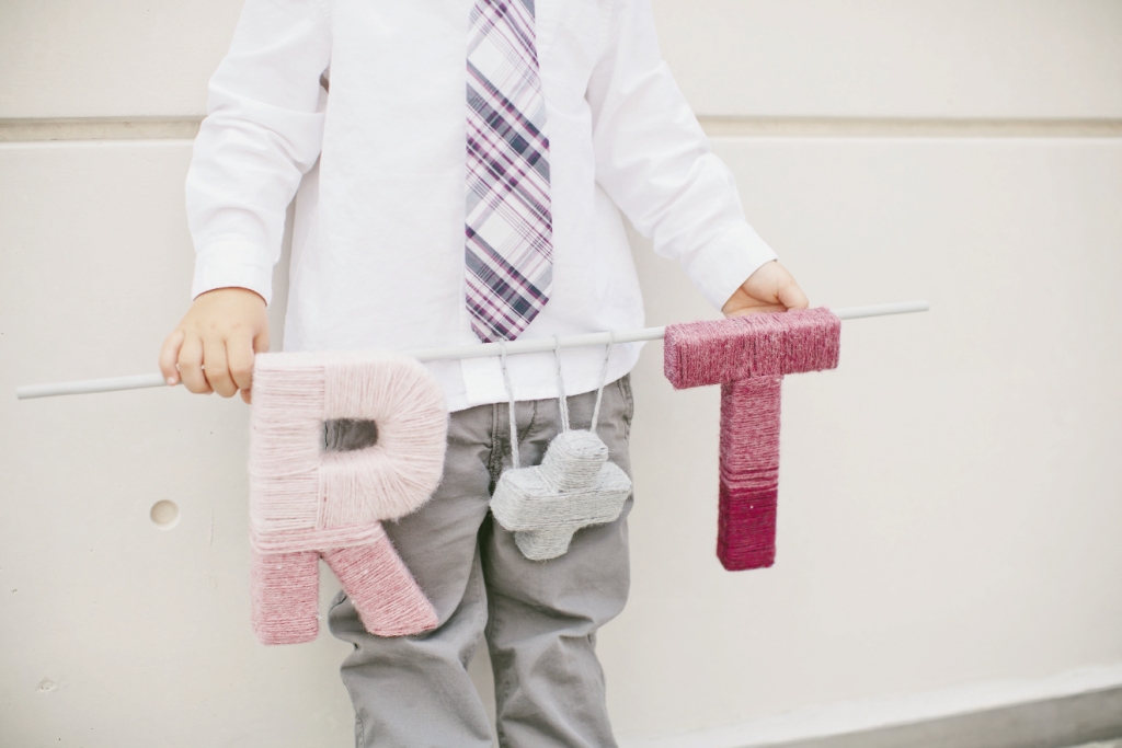 INITIAL INTRODUCTION: Thomas’ nephew carried an “R + T” banner made from yarn wound around cardboard letters.