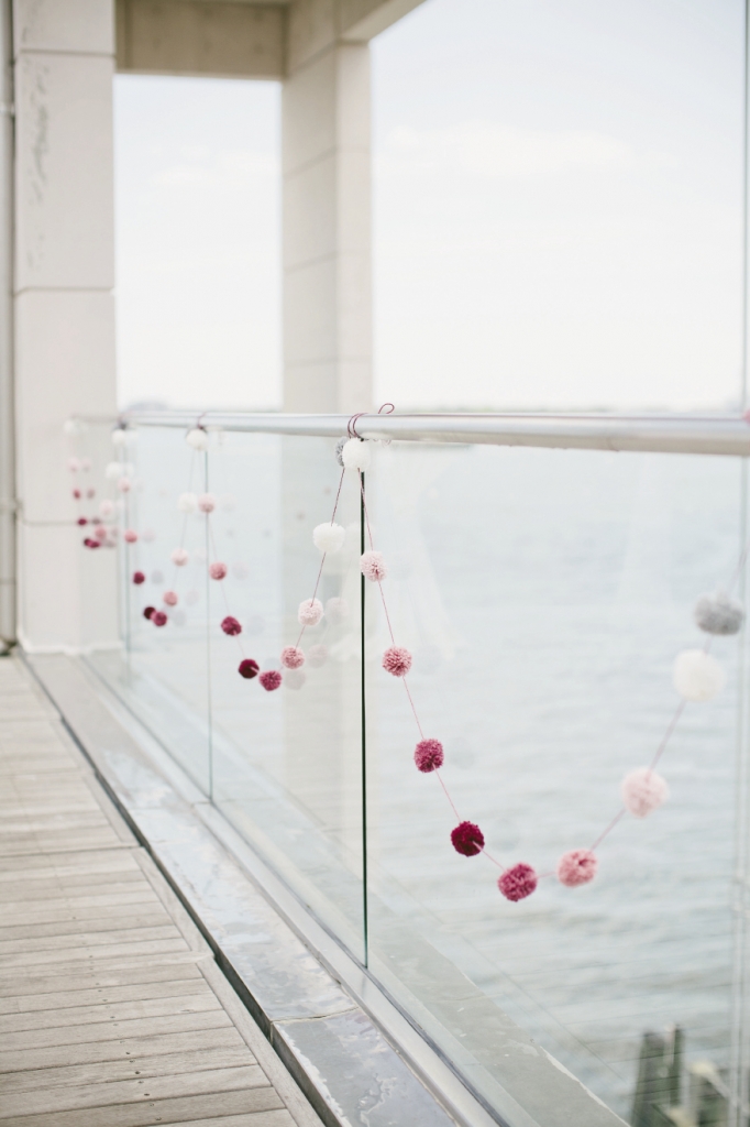 DELICATE CONTRAST: Pom-pom garlands hung along the balcony for subtle punctuations of color.