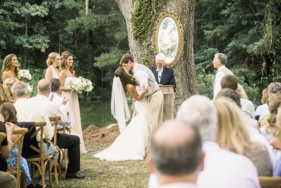 Ooh! Events hung an antique mirror on the altar space’s towering oak to afford guests a peek at the couple’s expressions during the ceremony.