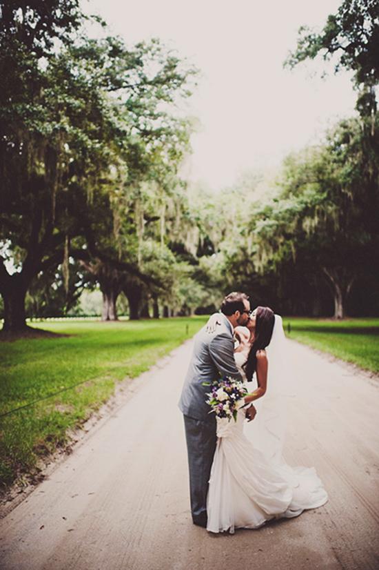 ALL YOU NEED IS LOVE: The newlyweds kissed for the camera on the oak-lined dirt drive of Boone Hall Plantation.