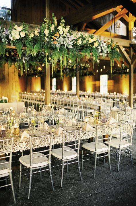 NEW HEIGHTS: Julie adorned the Cotton Dock’s wooden rafters with flowers from A Victorian Flower Dictionary, which gives each bloom a unique meaning. Peach-hued peonies symbolize a happy marriage while yellow roses are for contentment. The ferns and Spanish moss served as a nod to the Lowcountry.