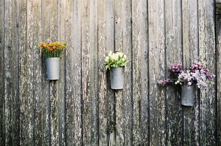 HANGING AROUND: Friend-turned-planner Julie Righetti hung French market buckets stocked with clusters of like blooms—tulips, alstroemeria, and spray roses—along the Cotton Dock’s exterior walls.