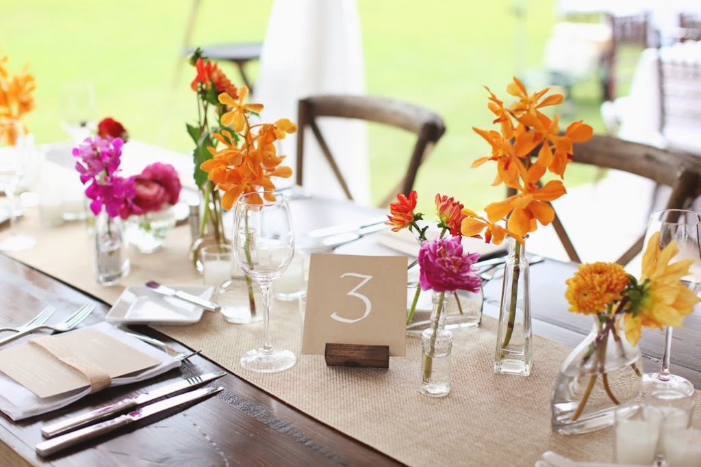 SIMPLE TOUCHES: Table numbers penned onto kraft paper matched the look of dinner menus, while flowers were tucked into clear vessels of varying shapes and sizes.