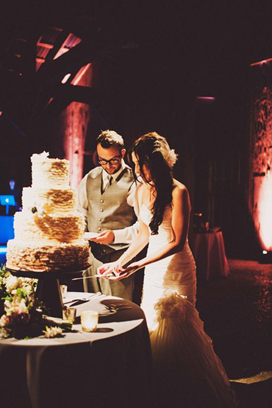 ALL ABOUT THE OMBRE: Once the sun had set, the couple cut into their ombre-ruffled wedding cake.