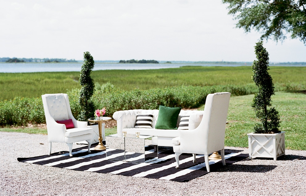 Lounge areas were defined by black and white striped rugs, and outfitted in white leather seating with emerald-hued velvet pillows and mirrored side tables.  &lt;i&gt;Photograph by Gayle Brooker&lt;/i&gt;