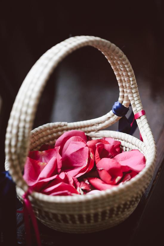 IN PIECES: The flower girls carried deep pink rose petals in sweetgrass baskets. To reiterate the palette, navy and pink ribbons were tied to the basket handles.