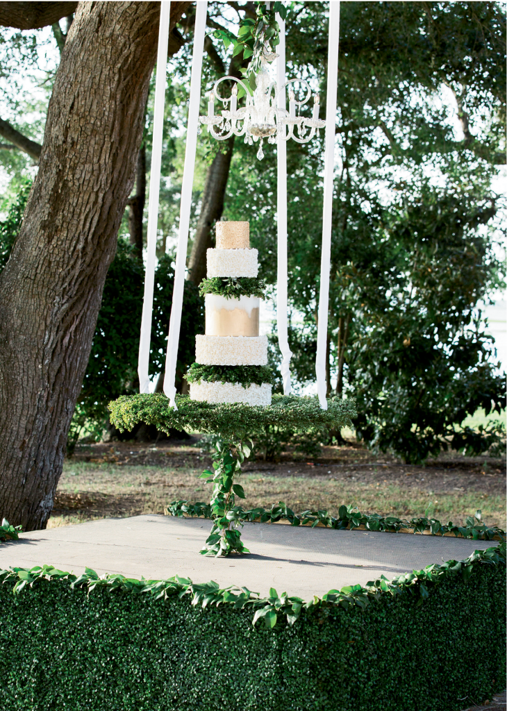 To prevent the cake from swinging during the cutting, Lauren’s team ran a greenery-covered cable from the stage to the platform, thus securing the dessert by Patrick Properties pastry chef Jessica Grossman.   &lt;i&gt;Photograph by Gayle Brooker&lt;/i&gt;