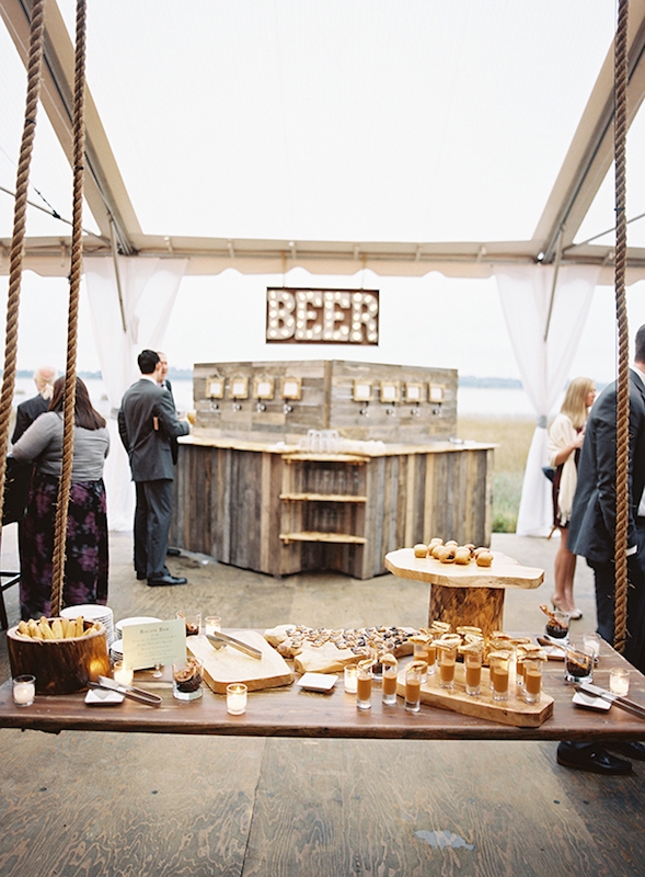 Many elements were riffs off the bride&#039;s restaurant, Bay Street Biergarten, like this “beer wall,” which, Laura says, gave guests more brew options than standard bar service generally affords. Catering by Patrick Properties Hospitality Group. Image by Virgil Bunao Photography at Lowndes Grove Plantation.