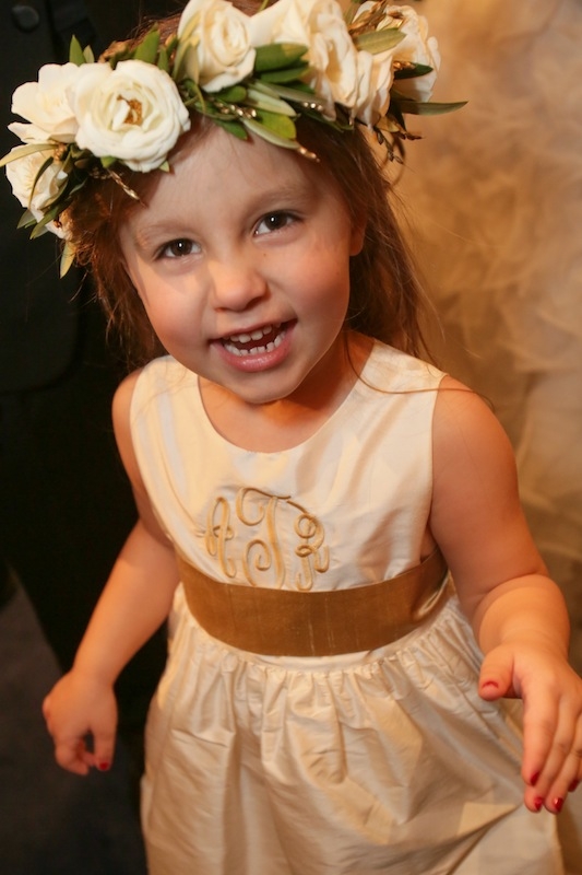 Flower girl dress by Coren Moore from Bella Bridesmaids. Floral headpiece by Charleston Stems. Image by The Connellys.