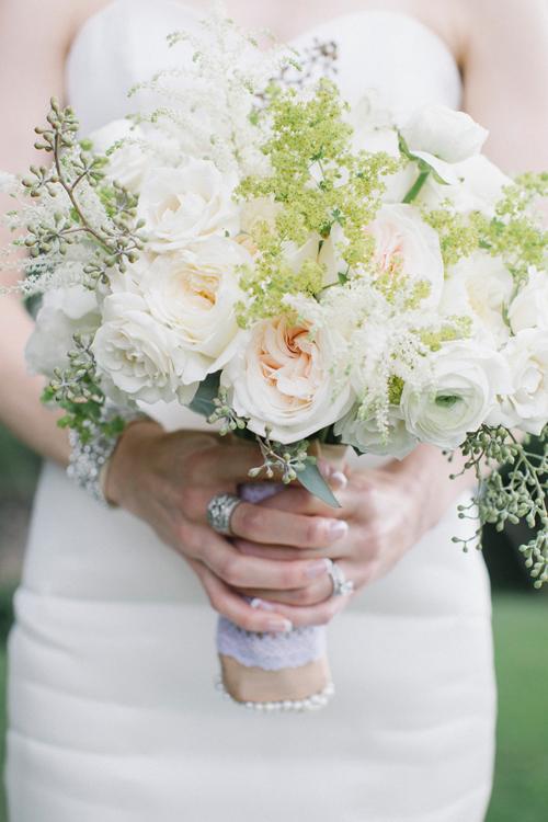 BLOOMING BEAUTY: Branch Design Studio married pale pink garden roses with white ranunculus and white spirea, dotted with stems of greenery, for Abby’s bouquet.