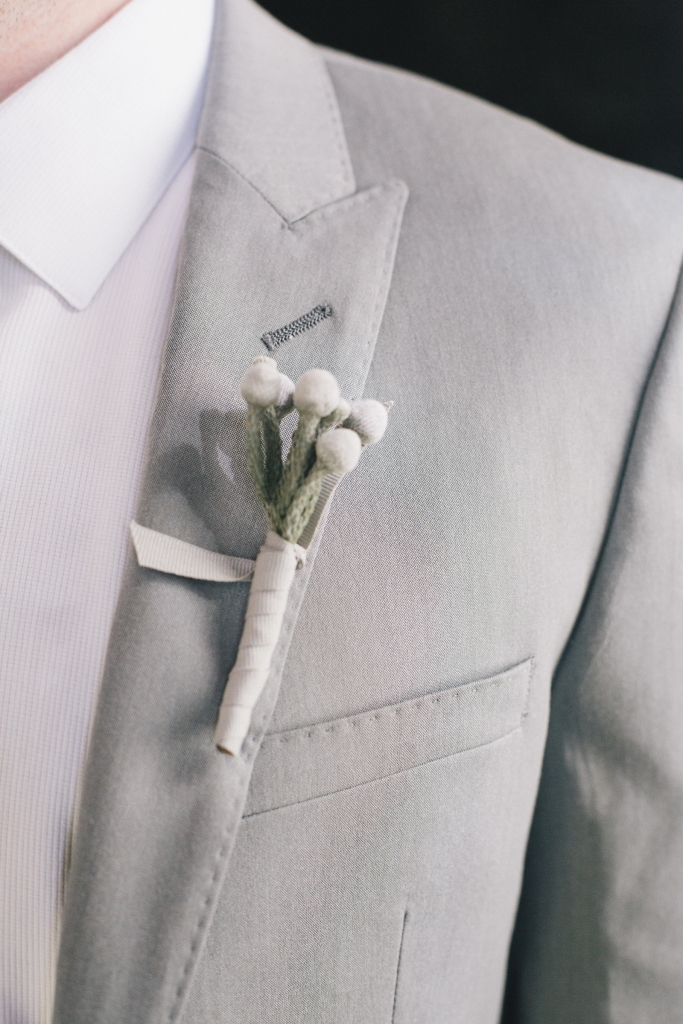 SOFT TOUCH: Tara Guérard pinned understated boutonnieres wrapped in white ribbon on the lapels of groomsmen’s light grey suits.