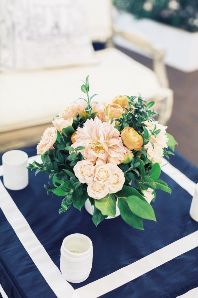 Greens dominated the setting, but a handful of blooms popped up in arrangements starring cheery, warming coral hues.