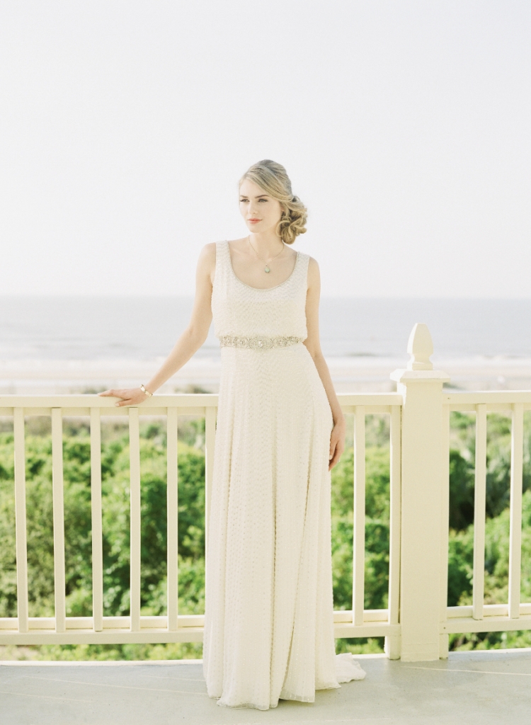 Oceanfront Oasis: Jenny Packham’s “Kathleen” scoop-neck gown with beading from White on Daniel Island. Phillips House’s 14K gold and diamond bangle from Croghan’s Jewel Box. CGC  Collections’ 24K  gold-plated necklace with opal pendant  from Finicky Filly.