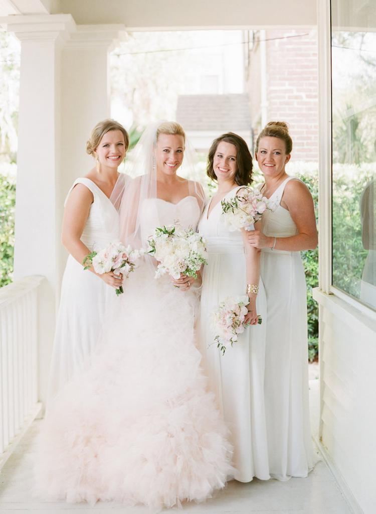 Bride&#039;s gown by Monique Lhuillier, available in Charleston through Maddison Row. Earrings by Ippolita, available in Charleston through REEDS Jewelers. Bridal styling by Lindsey Nowak and Cacky&#039;s Bride + Aid. Bridesmaids&#039; attire by Monique Lhuillier from Bella Bridesmaids. Florals by Gathering Floral + Event Design. Hair and makeup by Ashley Brook Perryman. Photograph by Corbin Gurkin.