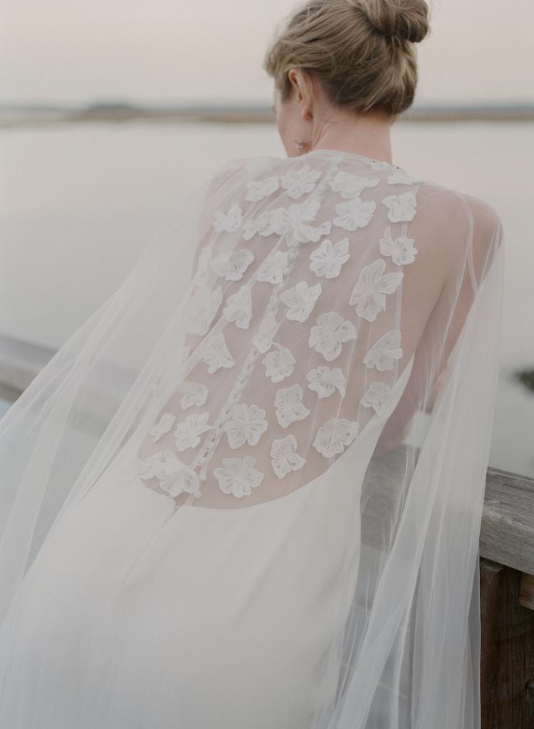 Lela Rose’s silk crepe “The Notting Hill” gown from Maddison Row. Allure’s tulle cape with beading from Verità. A Bridal Boutique. Ted Muehling’s pearl hoop earrings from RTW.