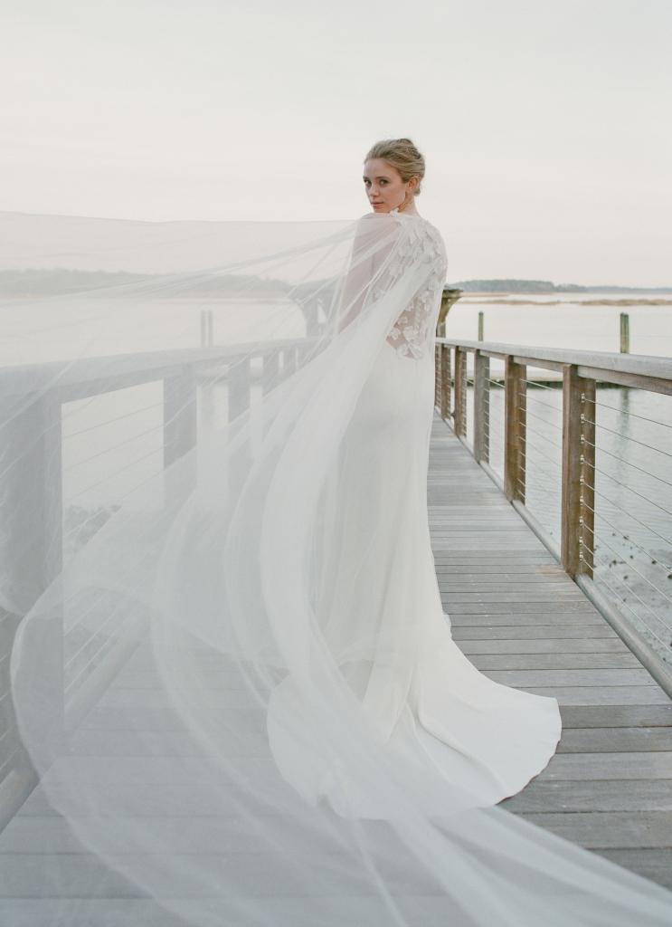 Lela Rose’s silk crepe “The Notting Hill” gown from Maddison Row. Allure’s tulle cape with beading from Verità. A Bridal Boutique. Ted Muehling’s pearl hoop earrings from RTW.