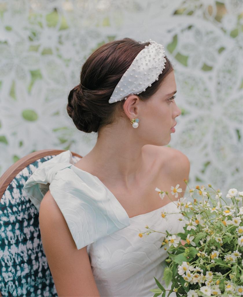 “The Reims” gown (with detachable blue shoulder bow) from Emily Kotarski Bridal. Mazza’s earrings from Croghan’s Jewel Box. “Posh” headband from Untamed Petals. Flowers grown by One Wild Acre. Lace Tyvek backdrop from Laser Cutting Shapes. Chair from Ooh! Events