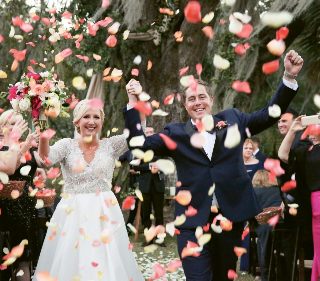 Emily Harkins and Christopher Christensen beamed through a shower of confetti-colored rose petals after being pronounced husband and wife at the Legare Waring House.  &lt;i&gt;Photograph Jennifer Bearden&lt;/i&gt;