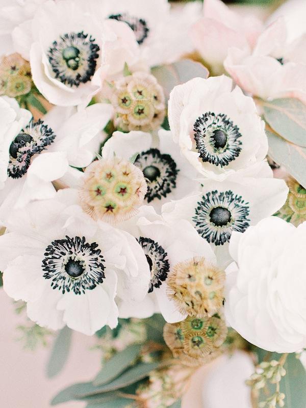 Arranged by the bride and her gals, arrangements of black-and-white anemones, scabiosa pods, and seeded eucalyptus sprang from simple glass vases.