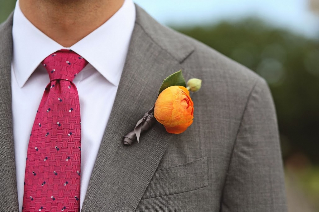 DAPPER DUDE: Engaging Events’ Judy Johnston polished off the groom’s handsome orange sherbet-hued ranunculus boutonniere with grey satin ribbon.