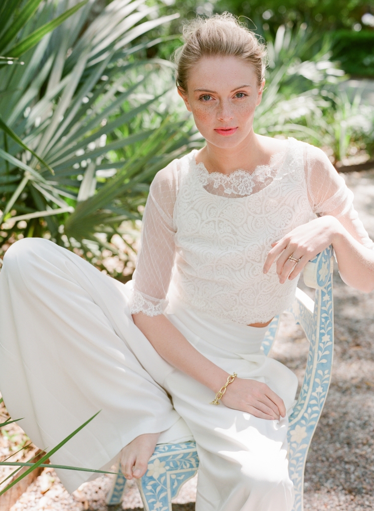 Nicole Miller’s “Skyscaper” palazzo pants from Out of Hand. Martina Liana’s “Tait” crop top from Gown Boutique of Charleston. My Story by Timeless Jewelry gold and diamond rings from Polly’s Fine Jewelry. Ippolita’s “Glamazon” bracelet from REEDS Jewelers. Chair from GDC Home