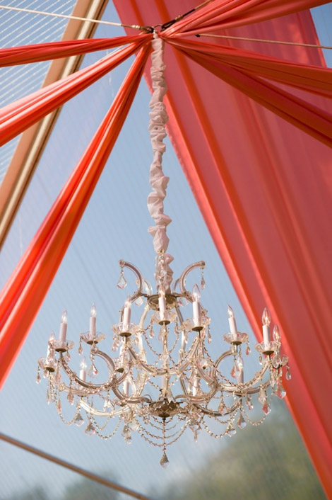 ABOVE AND BEYOND: Panels of coral fabric added color to the dance floor&#039;s clear-top tent, while a crystal chandelier provided an oh-so-elegant finishing touch.