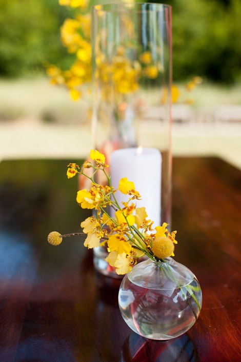 BEST BUDS: Petite drop vases holding yellow orchids added golden touches to reception florals.