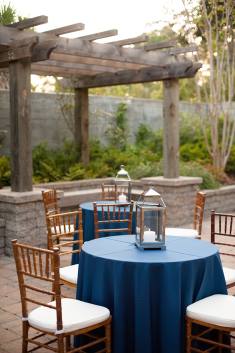 THE TABLES ARE SET: Deep gold Chiavari chairs and round cocktail tables draped in navy linens from Snyder Event Rentals offered patio seating in keeping with the wedding&#039;s rich palette.