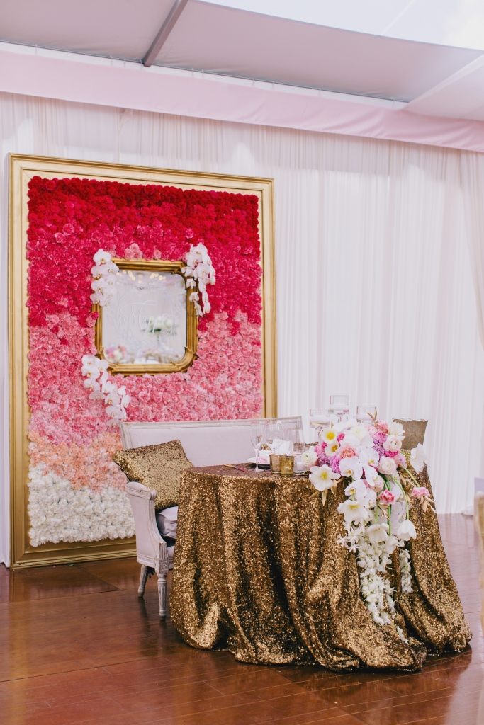 “We took every great idea we could come up with—sequin linens, cascading florals, vintage  seating—then backed it with a 10,000-stem, eight-foot ombré flower wall in a custom-built frame,” says Luke of the sweetheart table. The finishing touch? A mirror with the couple’s monogram. &lt;i&gt;Photograph by Hyer Images&lt;/i&gt;