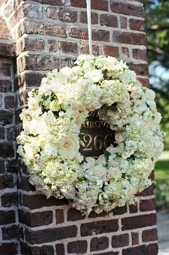 A WELCOMING WREATH: The Soirée team stuck roses, spray roses, peonies, lisianthus, stephanotis, spring tulips, and stock flowers into rings of flower foam to dress up the brick entrance of Lowndes Grove.