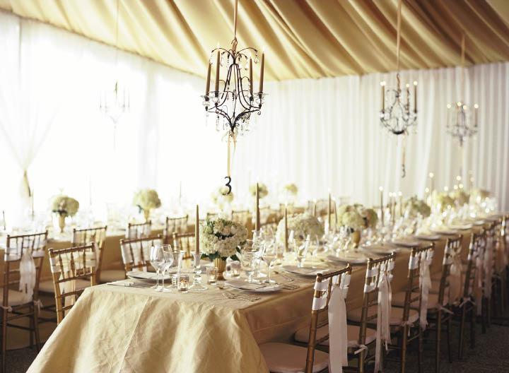 GET THE GLOW: Sheer white curtains  allowed natural light to fill the tent; when the sun set, candles and flame-lit  chandeliers brightened the space.