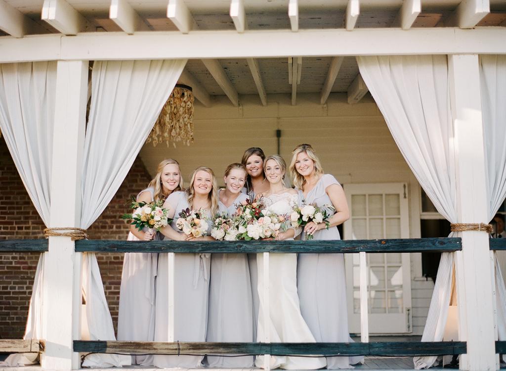 “It was one of my favorite moments of the day—to have that time with my bridesmaids before the evening really went into hyperdrive,” says Anna, pictured here with her sister, Sarah West, on her far left. “I really was shocked at the transformation. I knew it would look great but didn’t imagine how much I would love it!” The oyster shell chandeliers were a love-at-first-sight surprise, she says.