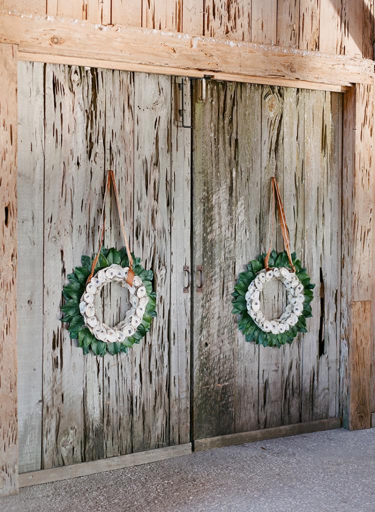 Homemade magnolia leaf and oyster shell wreaths hung from the dock doors with the same ribbon the bridesmaids wore as sashes.