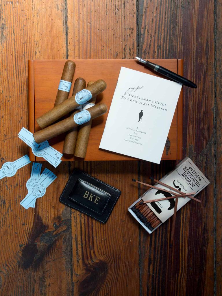 MANLY THINGS: Hand-rolled cigars with custom bands from Coastal Cigars. Moustache matches, pen, and Forgetful Gentlemen stationery from Ooh! Events. Money clip from Croghan&#039;s Jewel Box.