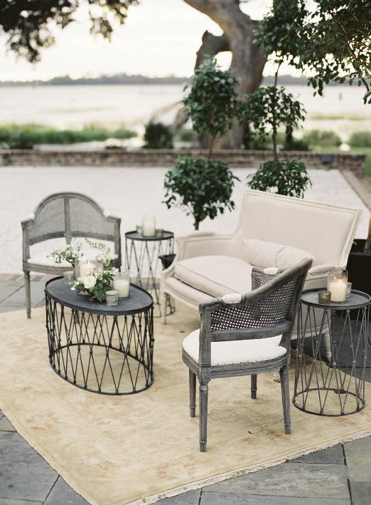 Easton Events created outdoor lounges with topiaries, Oriental rugs, cane-backed chairs from Snyder Event Rentals, linen settees, and wire side tables.