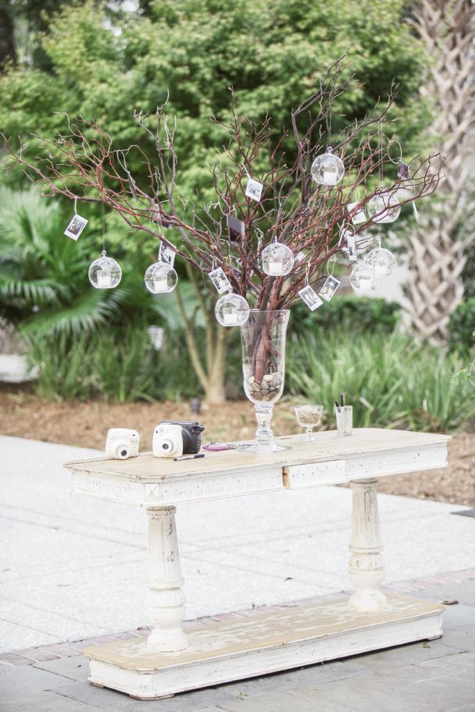 Guests took selfies with instant cameras and hung them from branches lit by crystal  votives. Later, the couple filed the images away in a keepsake album.