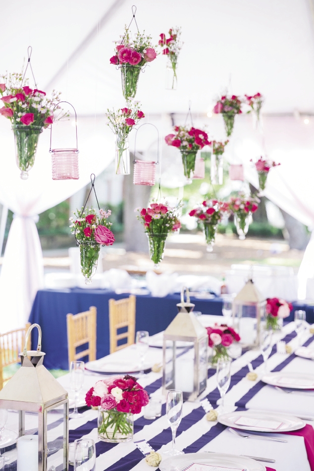 CLOSE QUARTERS: An airy cloud of spray roses, waxflower, ranunculus, and garden roses floated over the dining table in suspended glass vases.