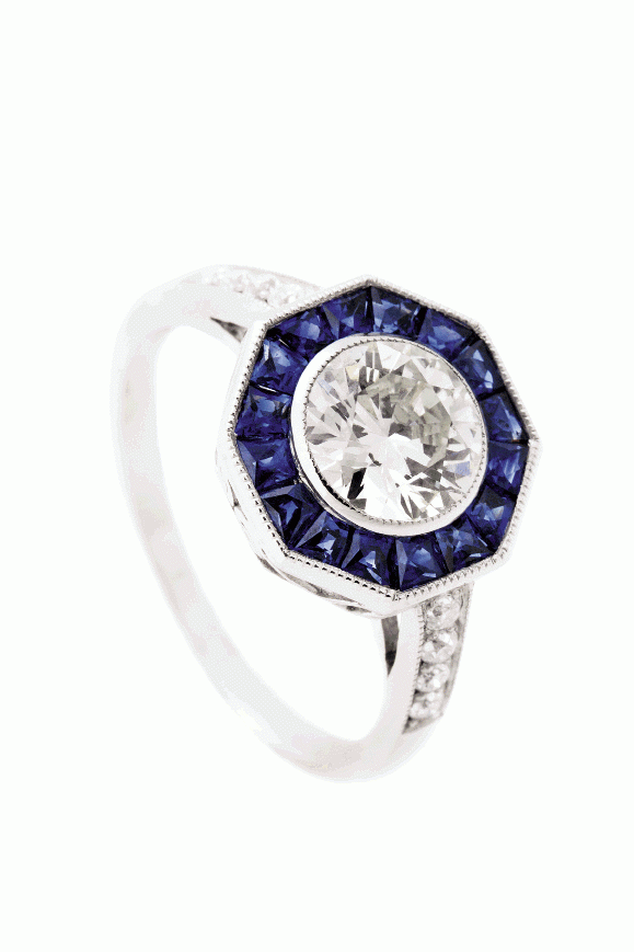 BLUE HEAVEN:  Platinum ring with a 1.10 ct. old European-cut, bezel-set diamond center, halo of sapphires (1.15 total cts.), and band inset with diamonds Croghan’s Jewel  Box, $13,900