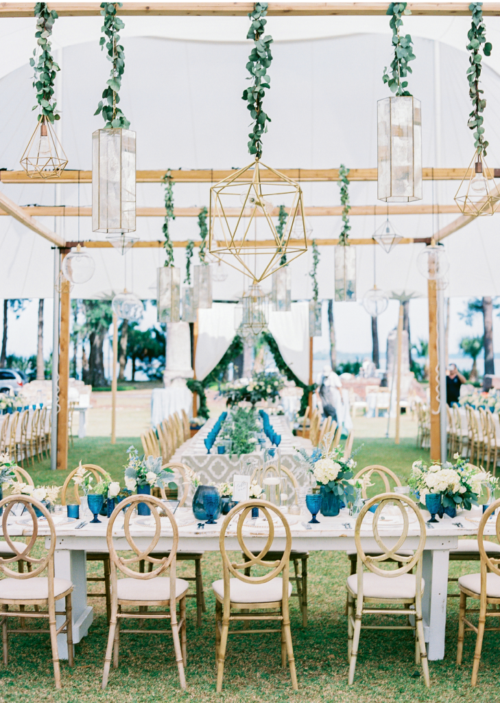 Even without side panels, a tent can define a space as with this outdoor “dining room.” Look closely to see the patterned runners on the tables; those sport the same design as the butler card tiles in the shot at left. As for the blue glassware, Carla fell for them long before she was engaged. When wedding planning kicked off, she tracked them down and bought 250 for the Big Day. Afterward, she divvied them up between her parents, her sister, and herself.
