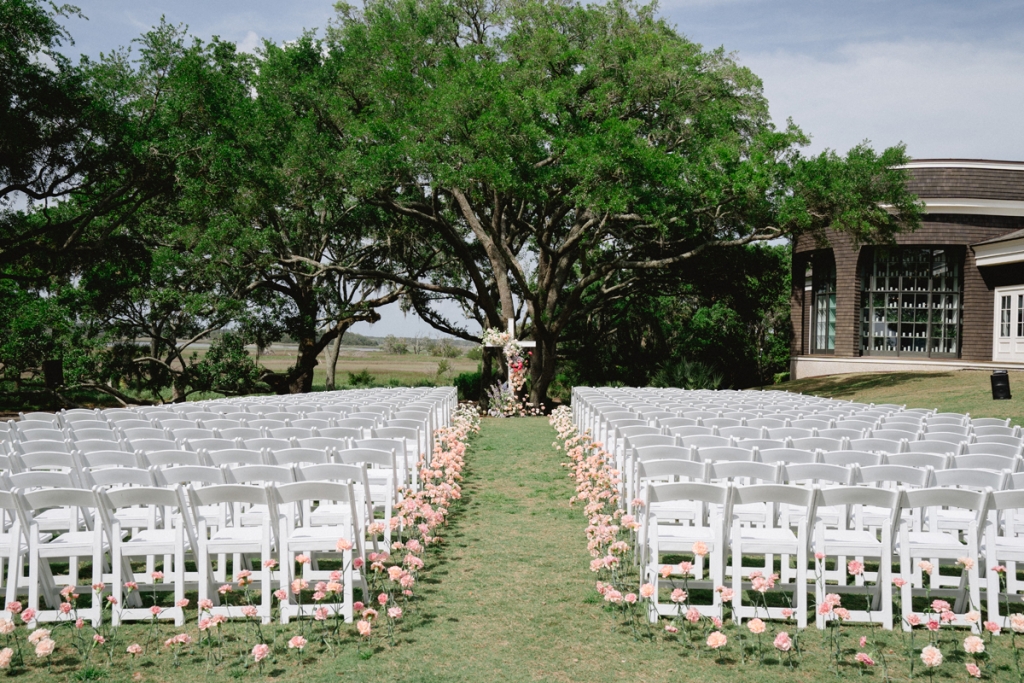 For the outdoor ceremony, a garden-style aisle lined with seasonal blossoms led to a flower-bedecked cross.