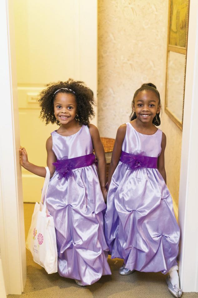 GIRL TALK: Flower girls Sydney and Trinity’s lilac dresses kicked off the purple parade. They had a blast, says Erica, “But Sydney barely made it down the aisle since she dropped all of her rose petals before she hit the guest chairs!”