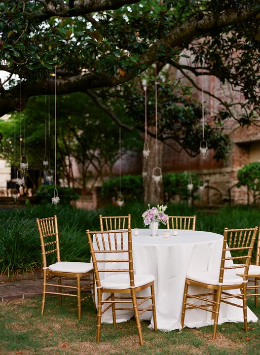 FAIRY LIGHTS: Tiny lanterns suspended from the garden’s ancient oaks lent a magical aura to the reception.