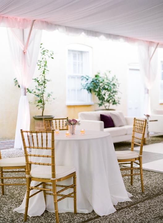 HOT SEAT: Metallic gold dining chairs stood out against white linens and gauzy tent fabric.